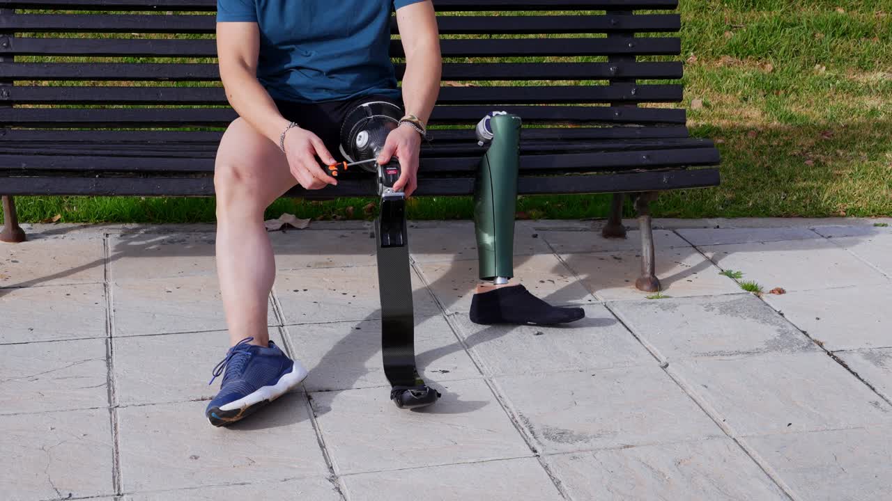 Person with leg prosthesis sitting on a bench