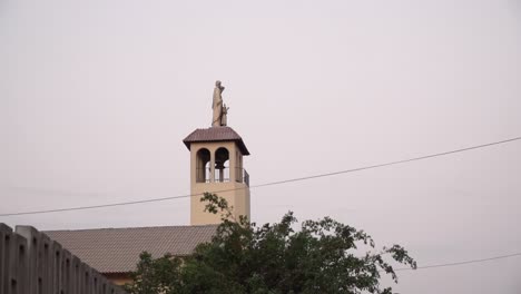 church steeple and statue during sunset in la molina, lima, peru panning from right to left