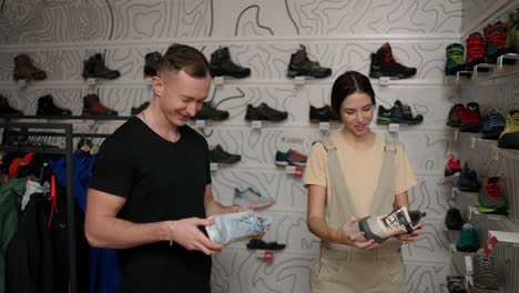 couple choosing new shoes together, woman holds new sneakers