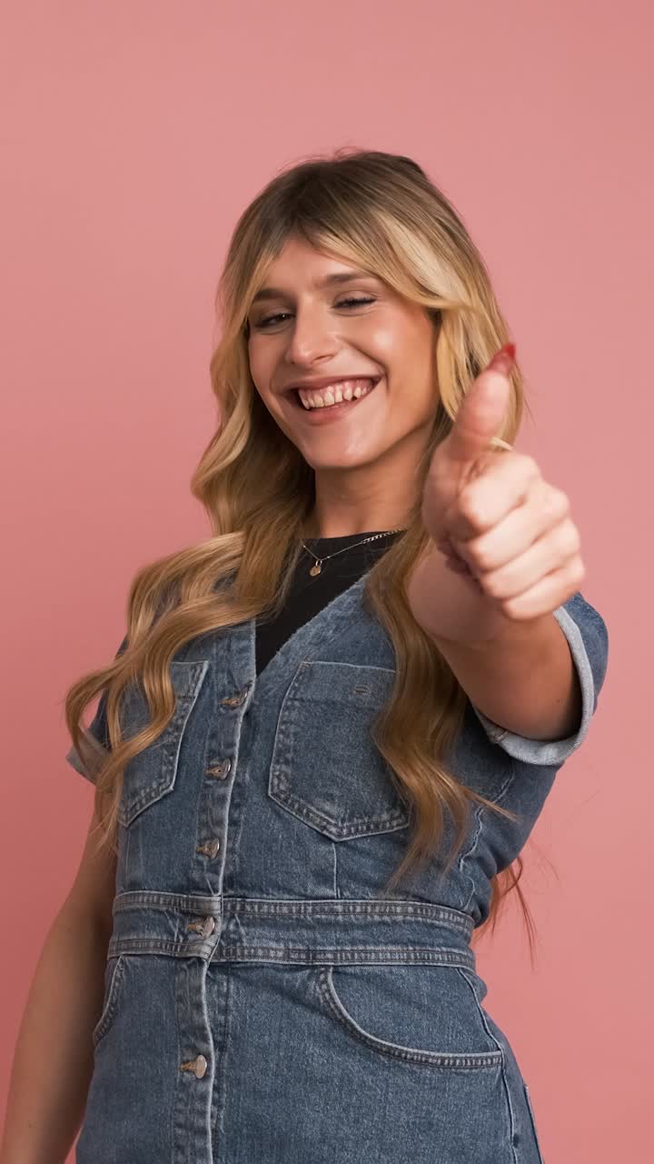 Contented transgender woman looking at camera and showing thumbs up