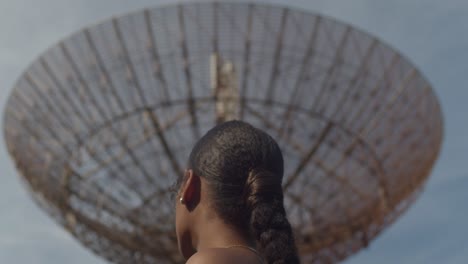 increíble primer plano de un modelo mirando una estación de seguimiento de radar en la distancia