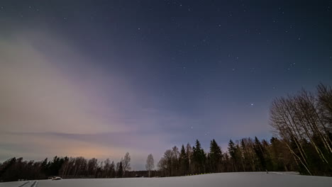 Lapso-De-Tiempo-Del-Cielo-Estrellado-Nocturno-En-Un-Campo-Nevado-Cerca-De-Un-Bosque-Con-Un-Amplio-Espacio-Para-Copiar