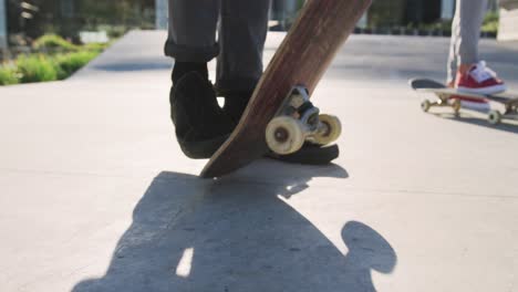 low section of caucasian man and woman skateboarding at a skatepark