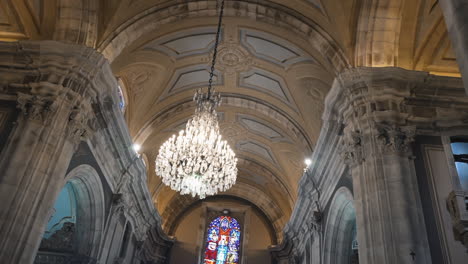 grand chandelier and stained glass in cathedral interior