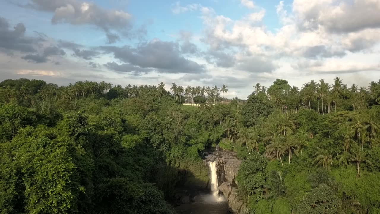 Inclinazione aerea verso il basso su una cascata di Bali, la Cascata di Tegenungan, Indonesia, con la foresta circostante