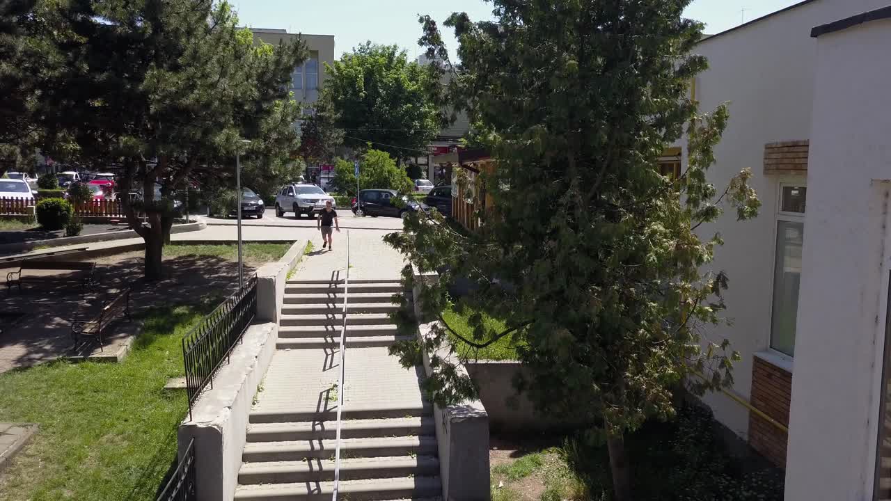 fotografía de seguimiento aéreo de un joven adulto corredor de parkour libre saltando y volviendo por las escaleras