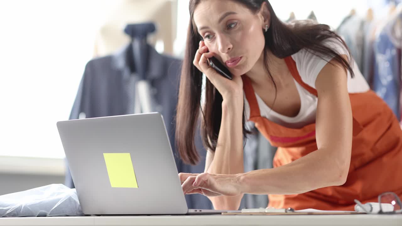 Woman seamstress accepting order by phone and writing on paper 4k movie