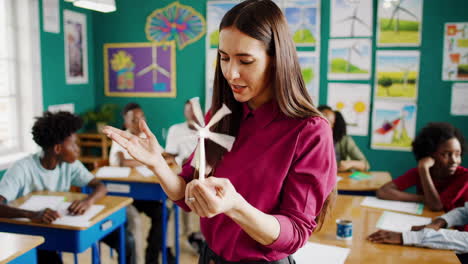 teacher demonstrating wind turbine model in classroom