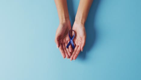 video de una doctora biracial con una cinta azul de cáncer de colon