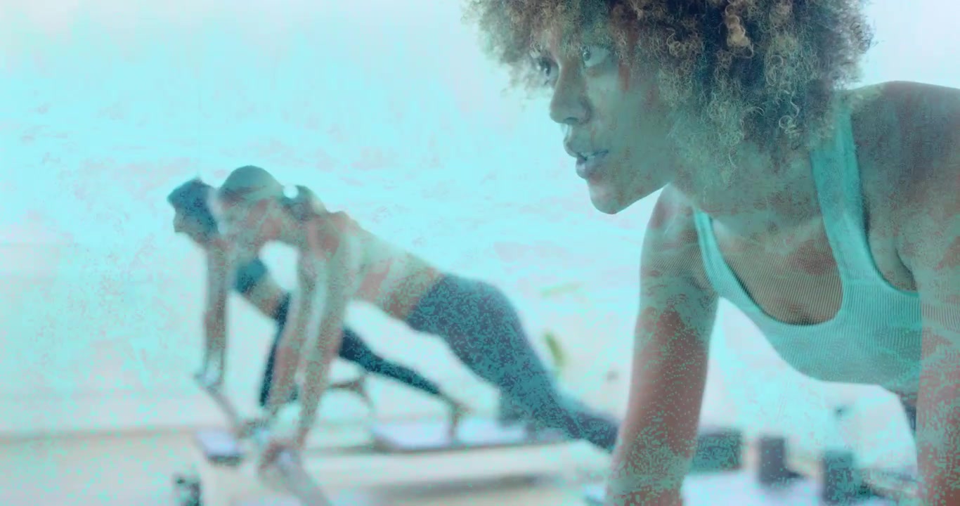 Three women performing reformer plank tucks in Pilates studio, instructor cue guiding core control