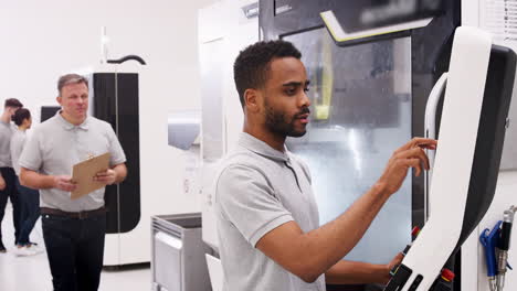 entrenamiento de ingeniero aprendiz masculino para usar la máquina cnc en la fábrica