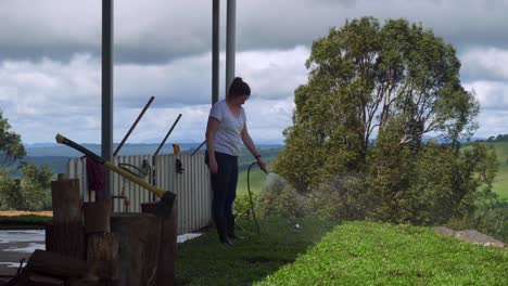 lady watering newly laid turf with garden hose