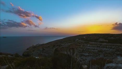 Hora-Dorada-Puesta-De-Sol-Sobre-El-Océano-Desde-La-Gruta-Azul,-Malta,-Lapso-De-Tiempo