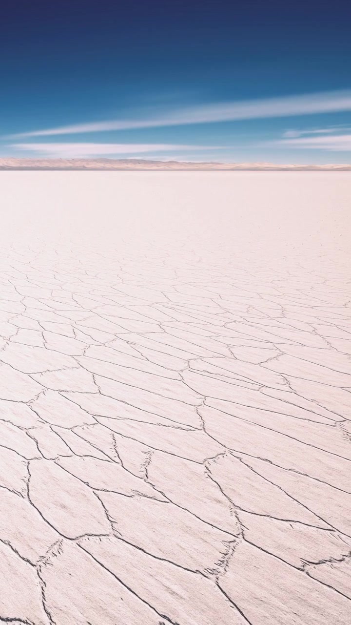 Vast salt flat landscape with cracked surface under clear sky