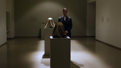 Woman and Covered Sculptures in an Art Gallery Exhibition