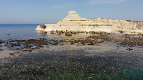 An-aerial-drone-shot-flies-across-the-Salt-Pans-and-crystal-blue-water-of-Gozo-Island-in-Malta