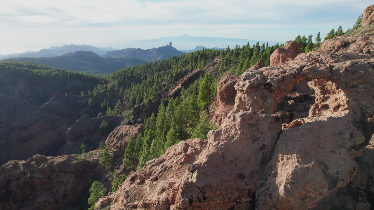 volando sobre la ventana del roque nublo en la isla de gran canaria y el volcán teide en el fondo