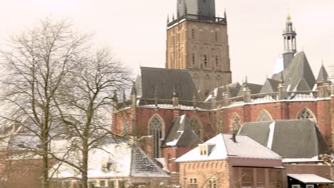 walburgiskerk rising above winter barren trees part of the cityscape of hanseatic city zutphen, the netherlands, covered in snow