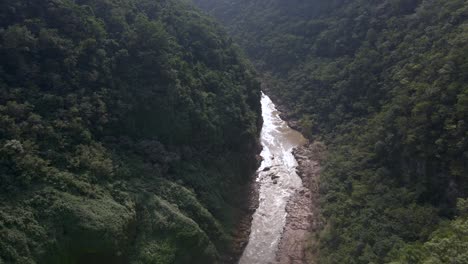 downcutting river flows at base of tamul waterfall in mexico forested jungle