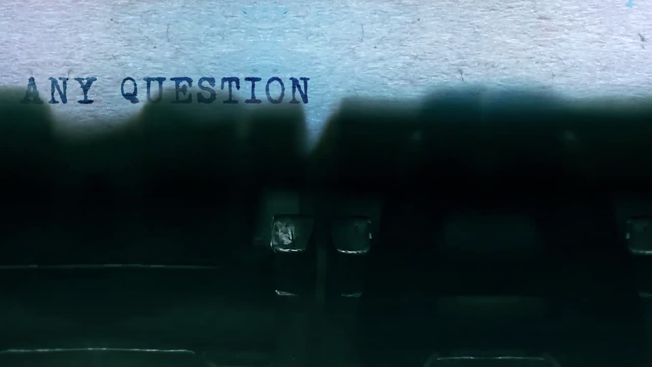 Any questions word closeup being typing and centered on a sheet of paper on old vintage typewriter