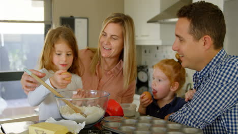 parents teaching their daughter to break the egg while baking 4k