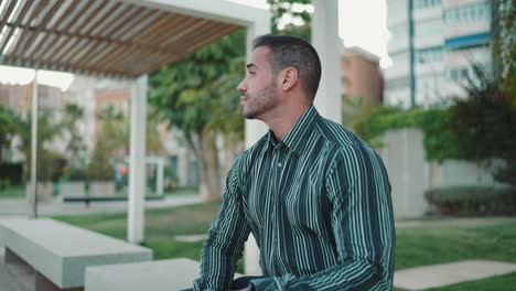 young man resting while sitting in bench outdoors.