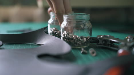 skilled tailor takes hollow nails hat rivets and puts