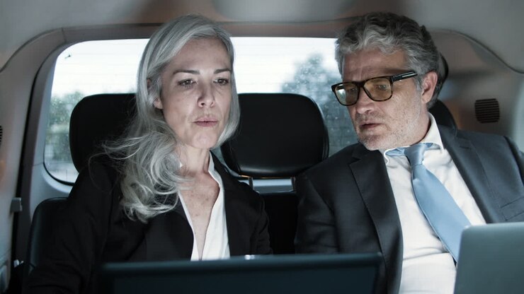 Donna e uomo che lavorano con i laptop in auto