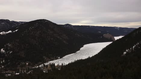 Cautivador-Paisaje-Invernal-Del-Lago-Paul-Rodeado-De-Majestuosos-Bosques-De-Hoja-Perenne,-Que-Lo-Invitan-A-Abrazar-La-Serenidad-Y-La-Tranquilidad-En-Kamloops,-Columbia-Británica