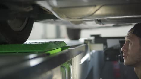 inspección del tren de aterrizaje del automóvil por parte de un mecánico