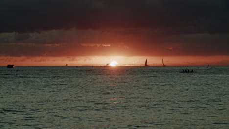 ocean sunset with boats and people