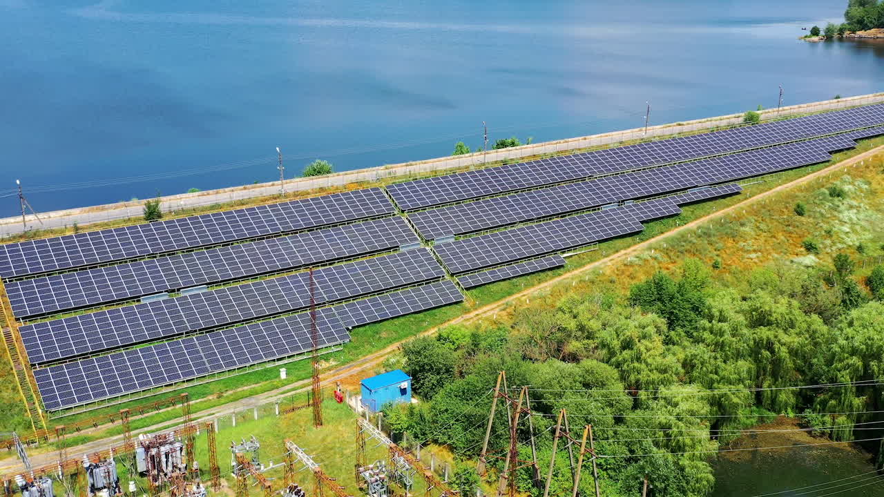 Solar energy farm on sea water background. Blue photovoltaic panels get sunny energy. Renewable source of green eco energy. Aerial view.