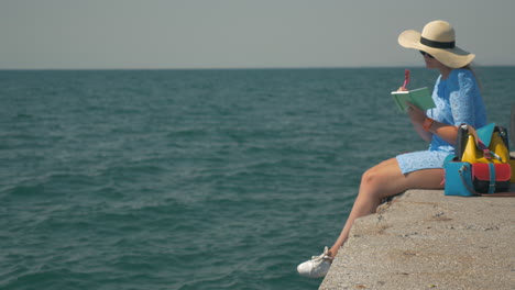 Woman-sitting-on-the-pier-and-taking-notes