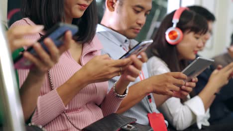 Young-people-using-mobile-phone-in-public-underground-train