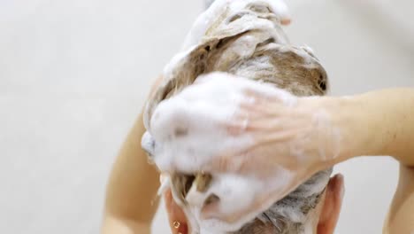 beautiful naked young woman uses shampoo while taking a shower in the bathroom hair washing procedure. close up.