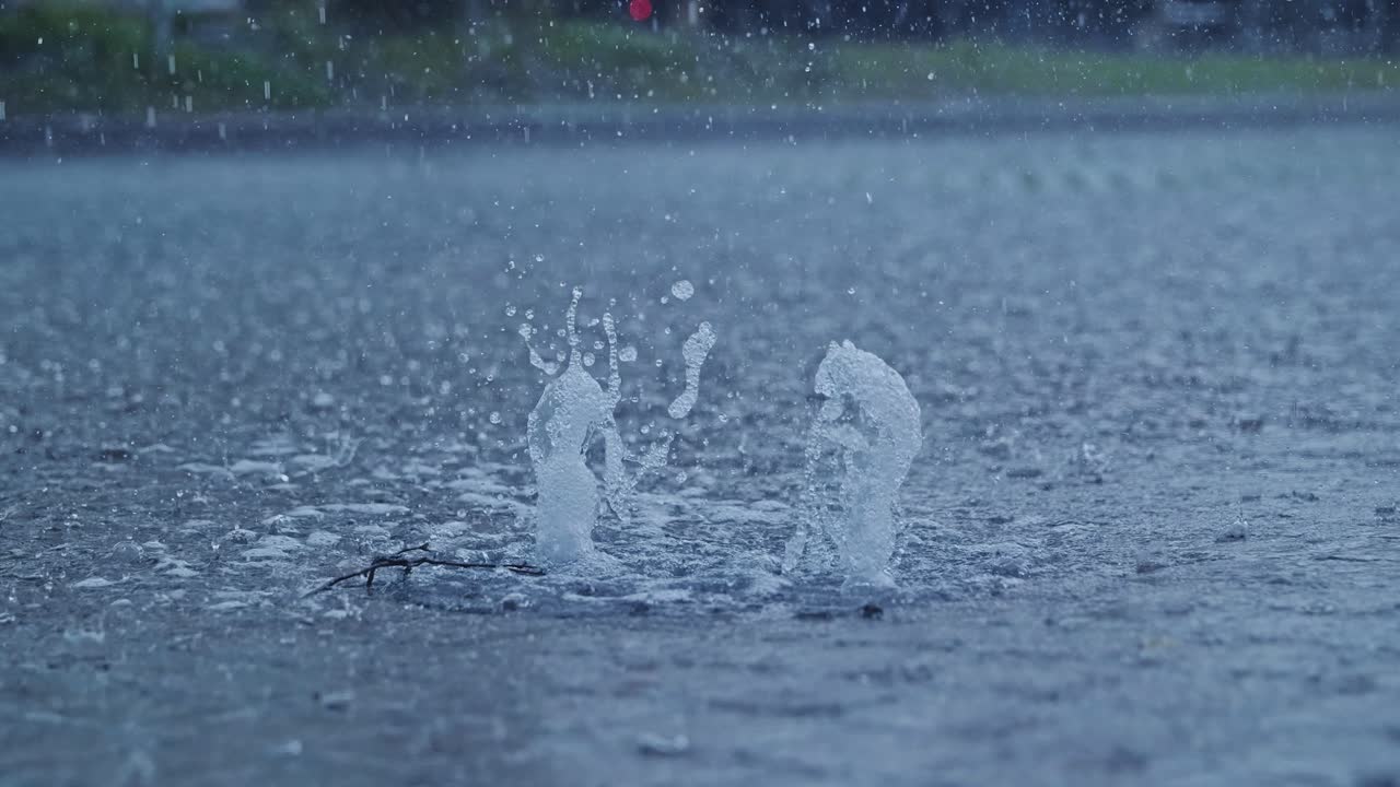 Intense downpour forces water to erupt from drain like urban street geyser