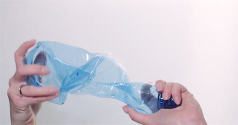 woman squeezing plastic bottle in hands plastic recycling concept