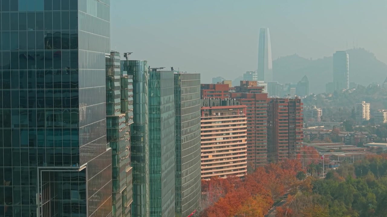 Dolly aéreo de drone aproximando-se dos modernos arranha-céus de Nueva Las Condes e do horizonte do Costanera Center em Santiago do Chile.