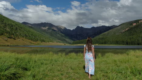 Filmische-Luftdrohne,-Die-Weiblichen-Frauen,-Model,-Schauspielerin,-Süßes-Kleid-Folgt-Und-In-Richtung-Piney-Lake-Ranch,-Vail-Beaver-Creek,-Avon,-Colorado,-Gore-Range,-Berglandschaft,-Sommernachmittagssonne,-Regenwolken-Geht