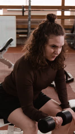 woman working out with a dumbbell in a gym