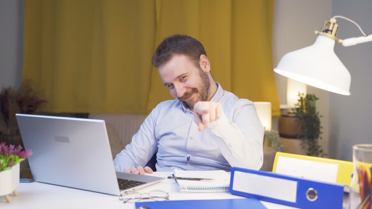 Home office worker man making cute gesture at camera.