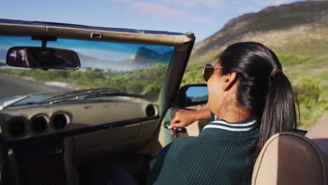mujer afroamericana hablando con su marido mientras estaba sentada en un coche descapotable