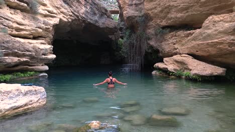 Beautiful-woman-take-bath-in-cavern-full-of-water-idyllic-landscape-called-"Salto-del-Usero"-in-Bullas,-Spain