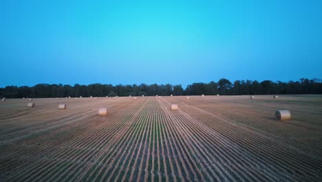 flying above the field with hay rolls sunrise.