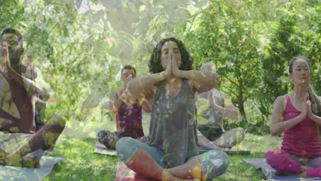 Animation-of-leaves-over-diverse-people-practicing-yoga-and-meditating