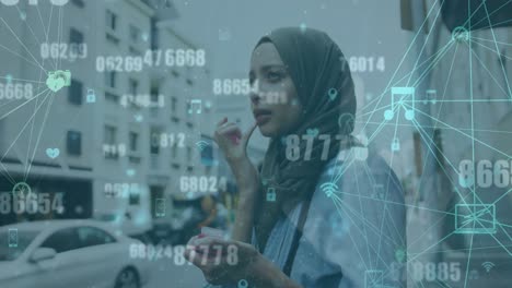 animation of numbers, connected icons globes, biracial woman wearing hijab applying cream on lips