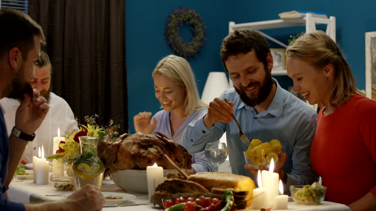 amigos alegres teniendo una cena de acción de gracias juntos
