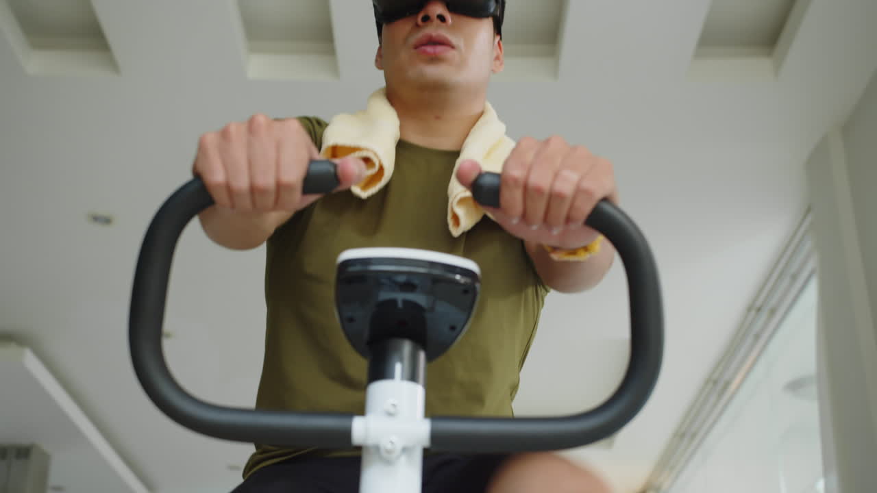 Man Using AR Headset when Working Out on Fitness Bike at Home