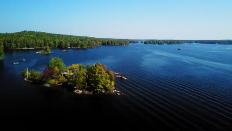 Imágenes-Aéreas-Sobre-Un-Lago-Azul-Tranquilo-E-Islas-En-Un-Hermoso-Y-Soleado-Día-De-Verano