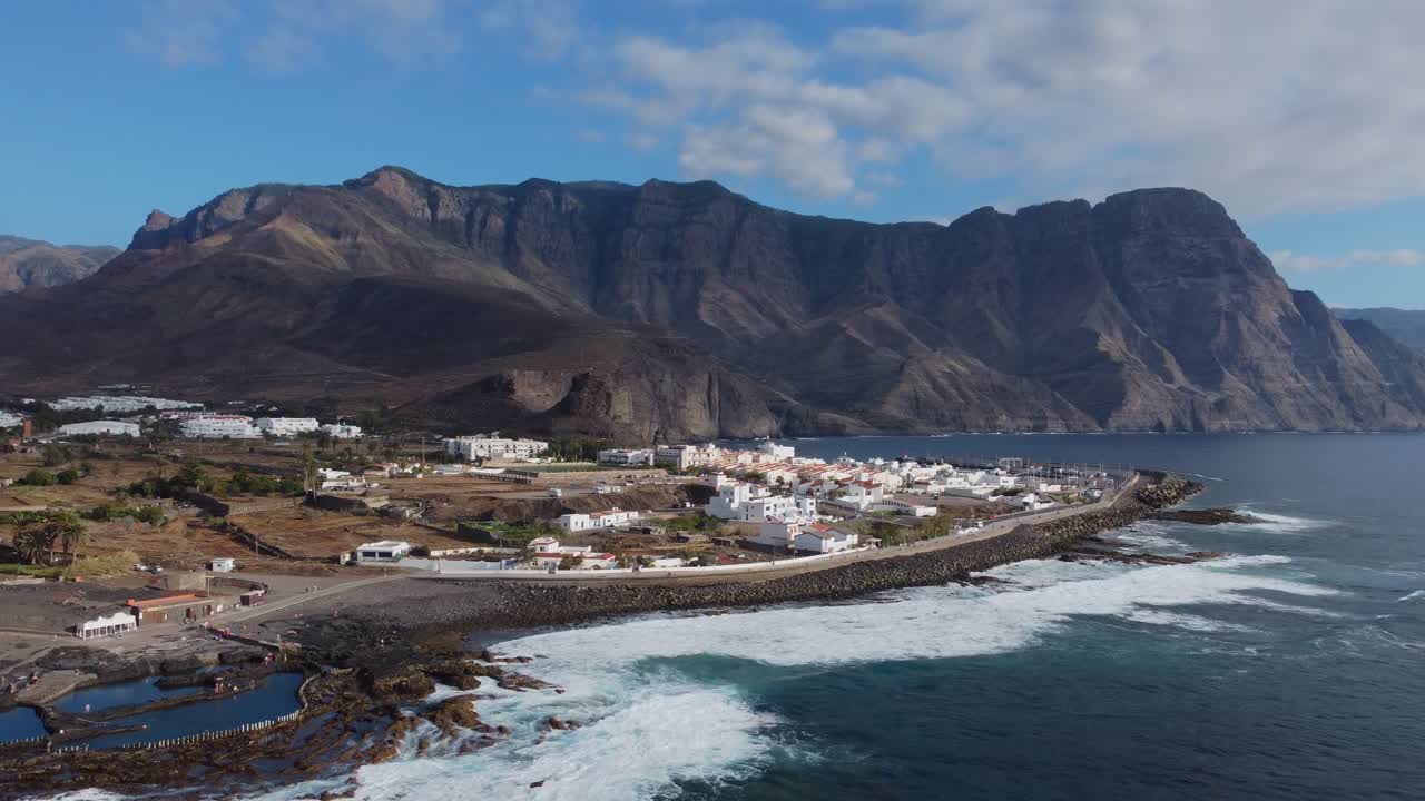 Cinematic circling of small fishing village on breathtaking coast of Gran Canaria, Spain